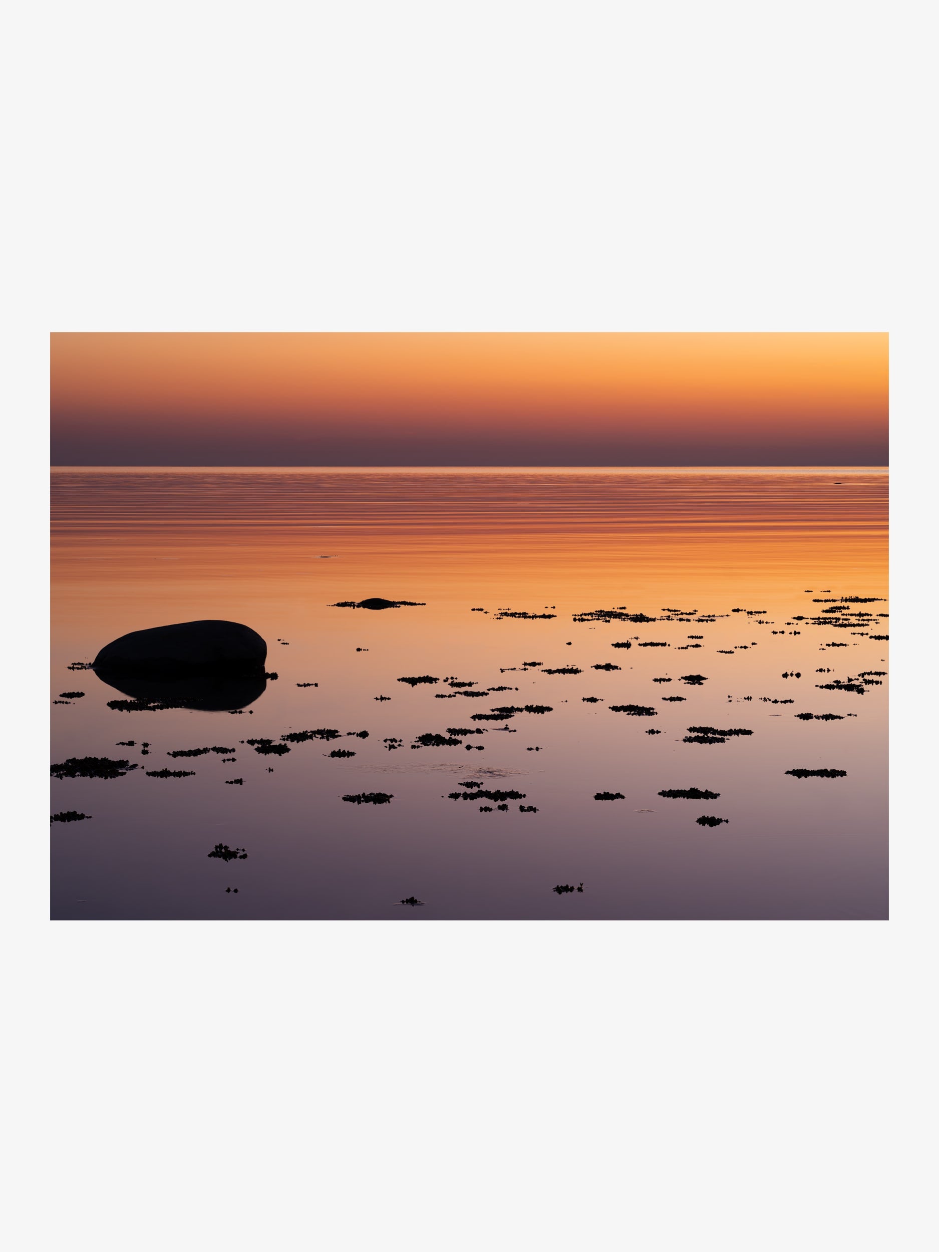 Calm Sea at Sunset with Reflections and Rocks