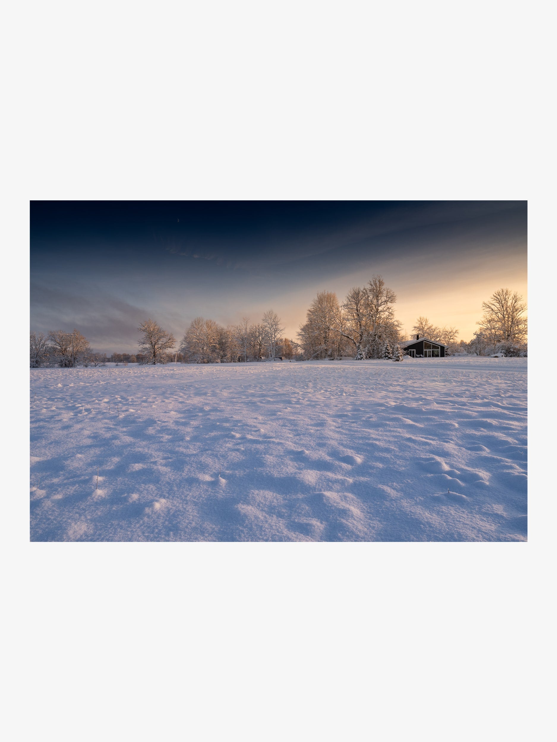 Winter Sunset over a Snowy Field with House and Trees