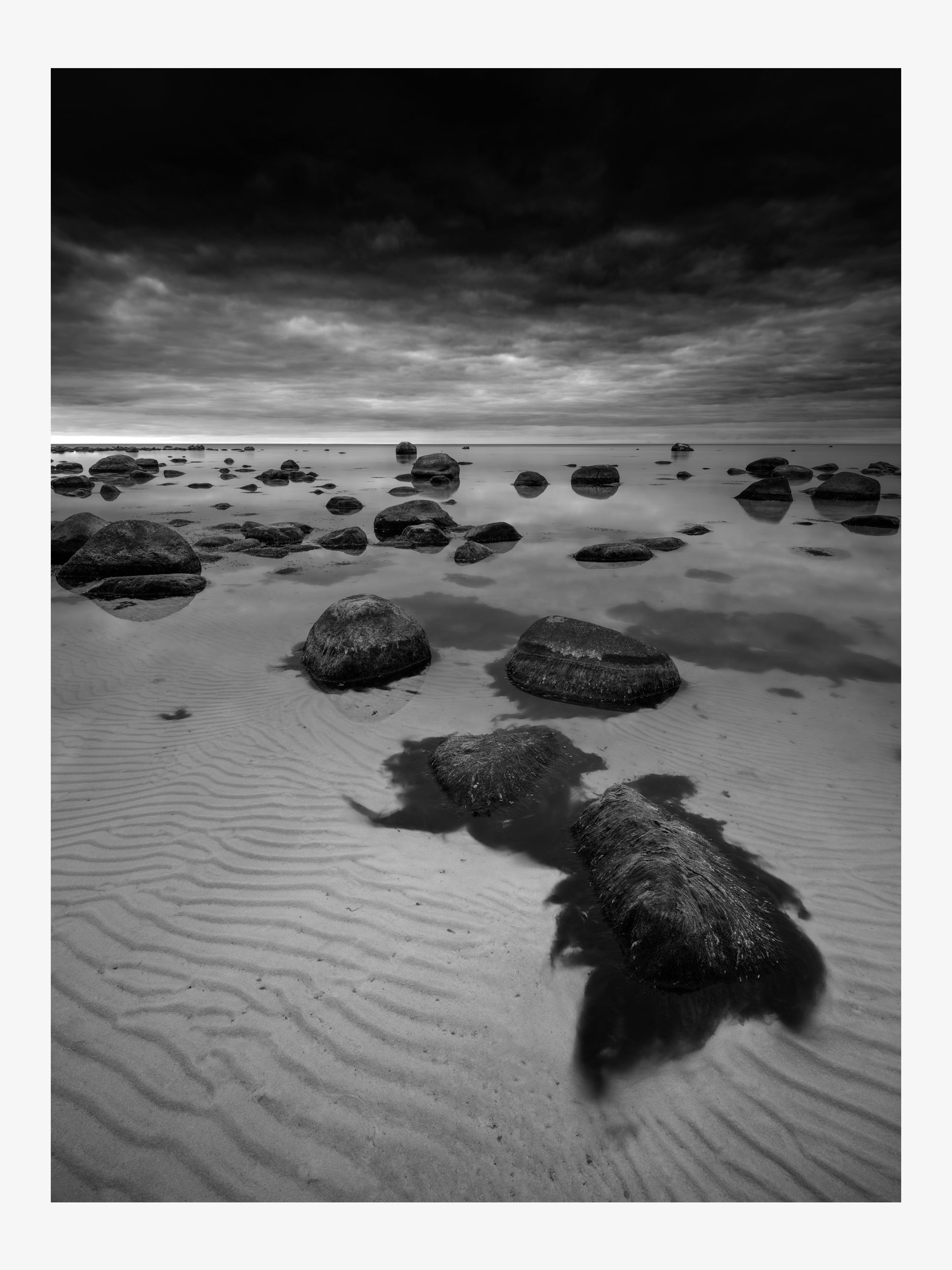 Stones in Shallow Water Under Cloudy Sky