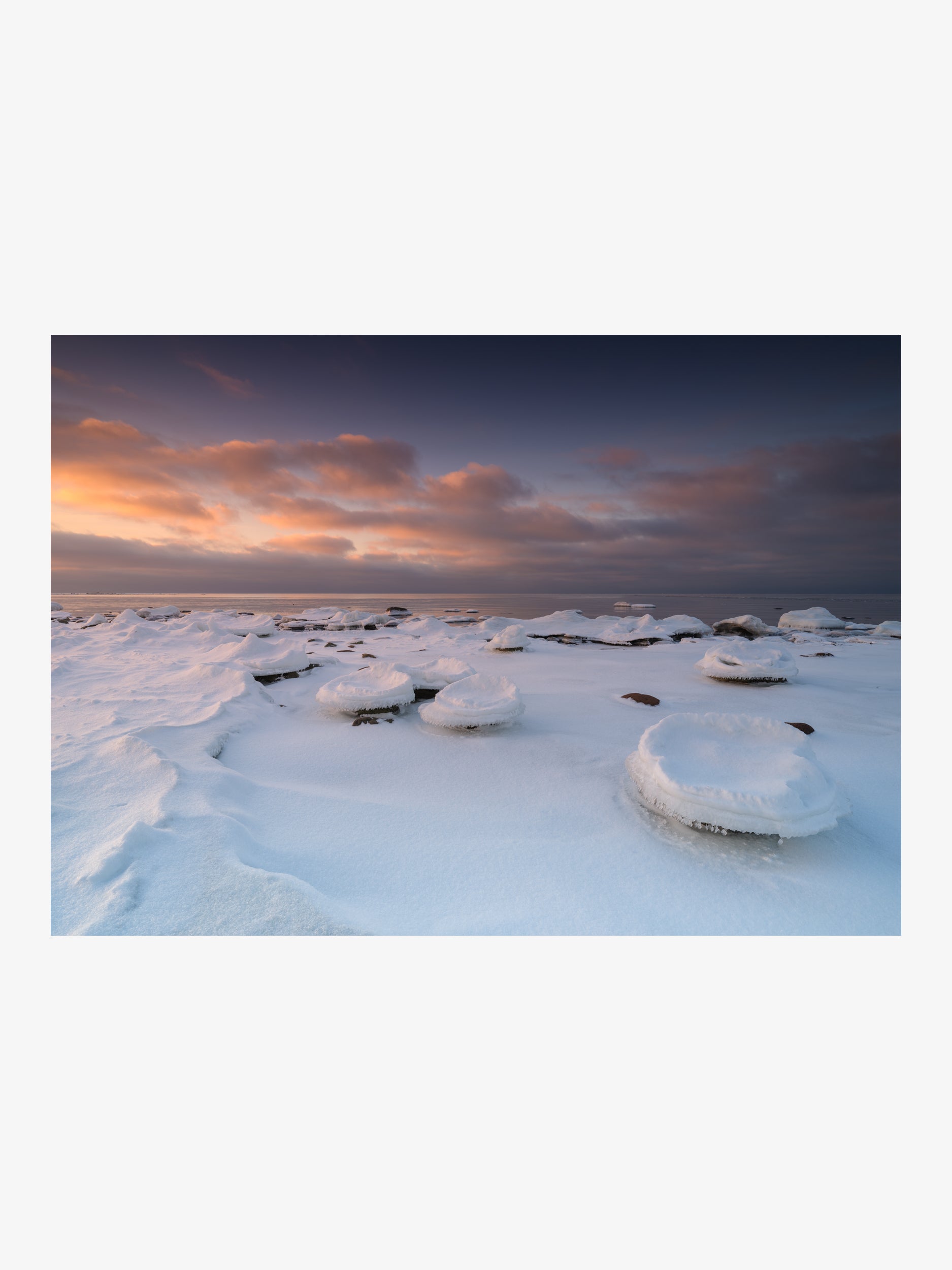 Snow-Covered Coastal Rocks at Sunset