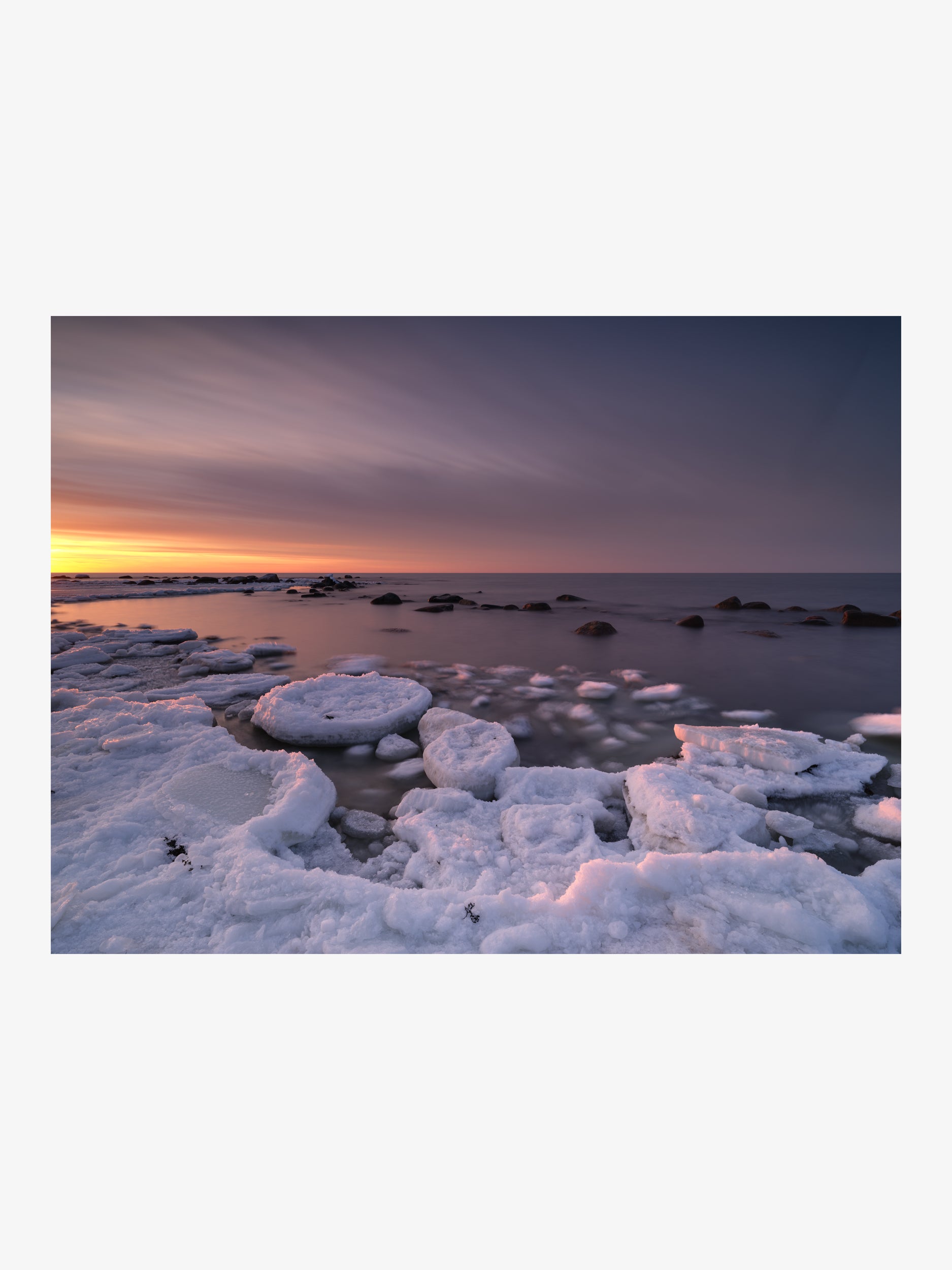 Winter Shore Softened by Long Exposure with Streaked Sunset Sky