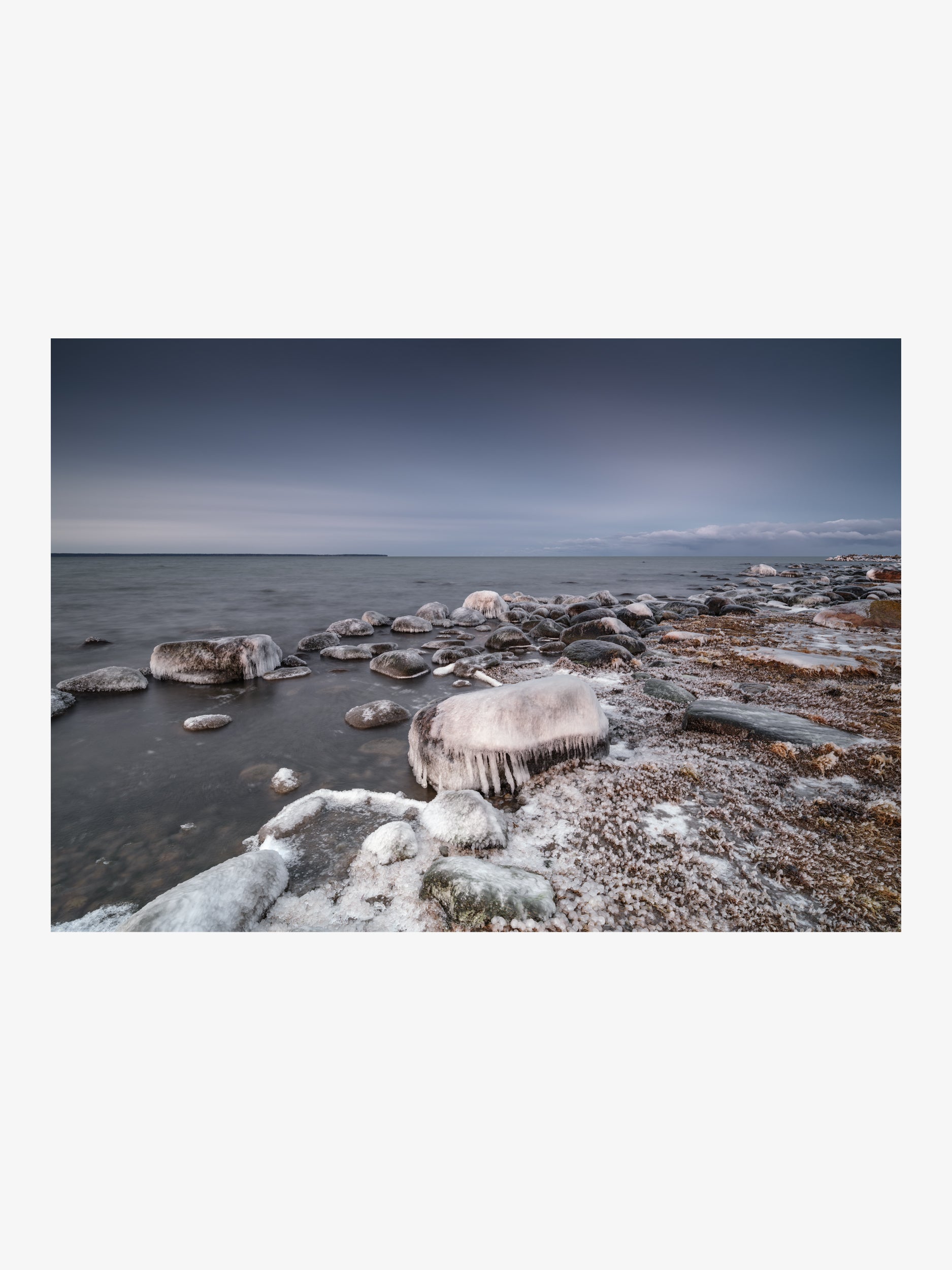 Ice-Covered Coastal Rocks with Icicles by the Open Sea