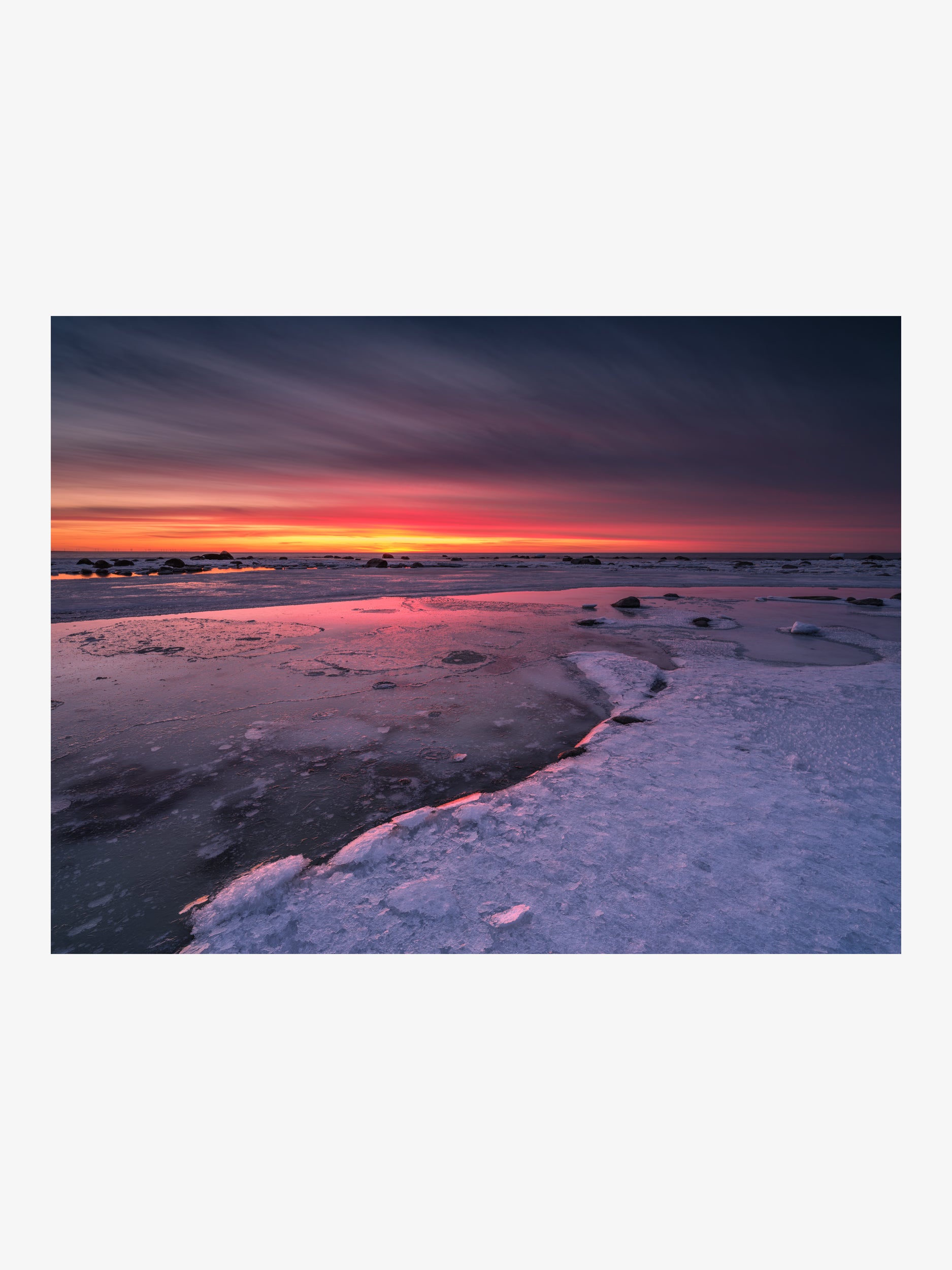 Fiery Red Sunset Over a Frozen Shore Reflected in Ice